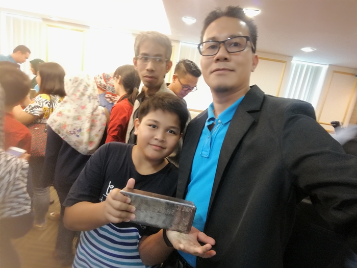 Adib memegang perak seberat 1 kg di bilik Dato' Wira Lois Ng