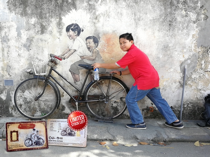 Adib bergambar bersama lukisan dinding ‘Skippy’ dan gambar kecil adalah emas 0.5 gram Public Gold